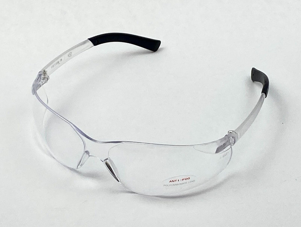 Anti-fog safety glasses on a tire shop workbench next to grip-wrapped tools