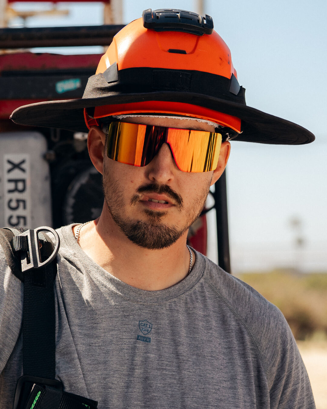 Tech in a hard hat wearing Heat Wave Visual Z87+ safety sunglasses on the job