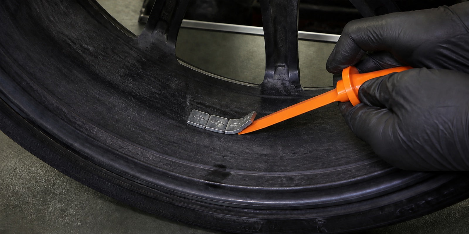 Technician removing an old adhesive wheel weight