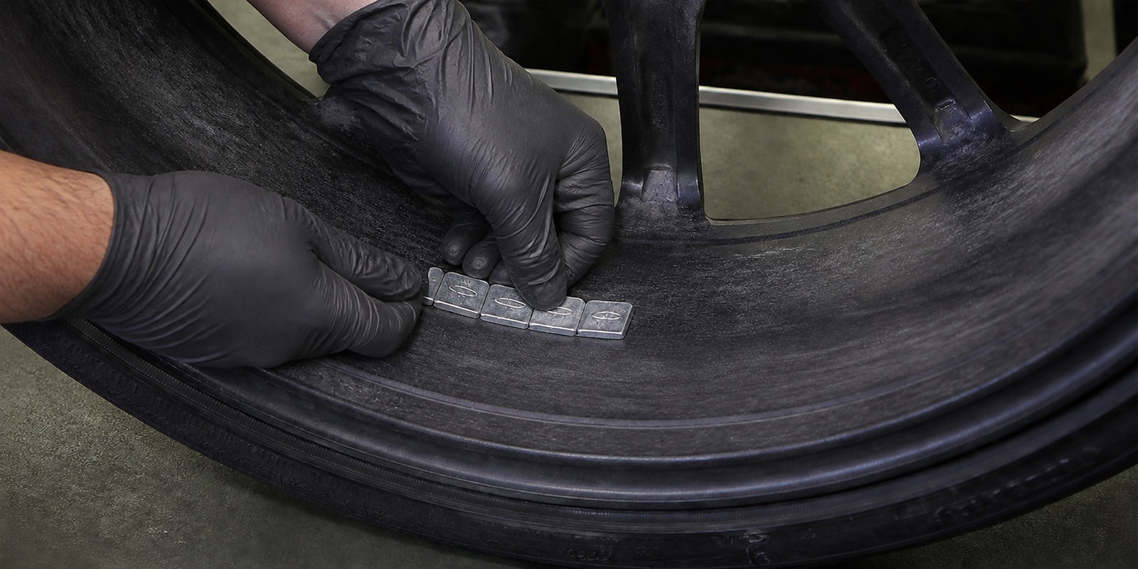 Technician applying new adhesive wheel weights